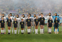 Iran's players salute and sing the national anthem before a group stage match against Australia at the 2026 AFC