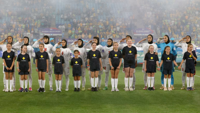 Iran's players salute and sing the national anthem before a group stage match against Australia at the 2026 AFC