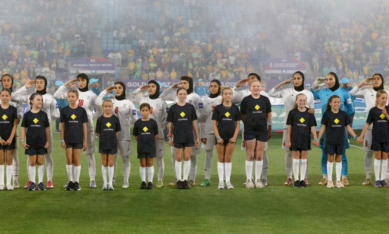 Iran's players salute and sing the national anthem before a group stage match against Australia at the 2026 AFC