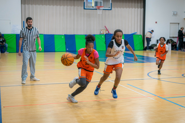 Girl basketball player training on court with ball-handling shooting and defensive drills